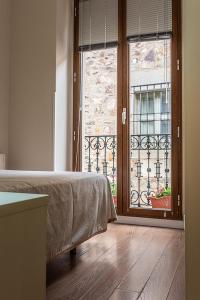 ein Schlafzimmer mit einem Bett und einem großen Fenster in der Unterkunft Domus Seleqtia Plaza de Santiago in Cáceres