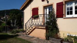 Casa con puertas rojas y balcón. en Gite du gros pommier, en Saulxures