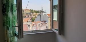 Una ventana abierta con vista a los edificios. en Roman Stadium Apartments, en Plovdiv
