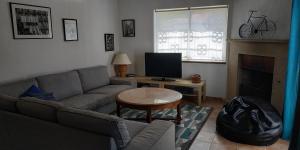 uma sala de estar com um sofá e uma mesa com uma televisão em Casa Albacor em Vilamoura