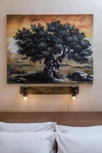 a painting of a tree on the wall above a bed at Ferienhaus Aretoussa in Pitsidia