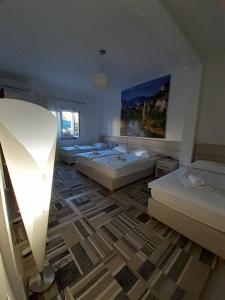 a room with four beds and a light in it at Guest House Vanja in Mostar