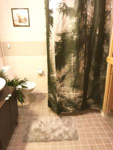 a bathroom with a shower with a tree at Garden City Apartment, Helsinki - Vantaa Airport in Vantaa