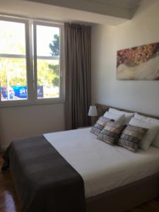 una camera da letto con un grande letto con due finestre di Martas Lisbon Apartment a Lisbona