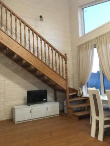 uma sala de estar com uma escada e uma televisão em Котедж Аквамарин em Yaremche