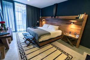 ein Schlafzimmer mit einem Bett, einem Tisch und einem Schreibtisch in der Unterkunft Elena de Cobre, Leon, a Member of Design Hotels in León