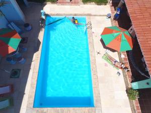 an overhead view of a swimming pool with two umbrellas at POUSADA MARINA PRAiA in Beberibe