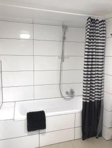 a bathroom with a bath tub and a shower curtain at Ellwürder Hof in Nordenham