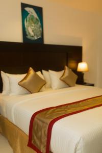a bedroom with a large white bed with several pillows at Saveira Colombo in Colombo