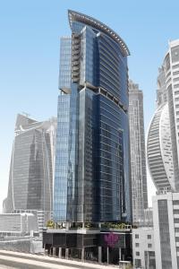 a tall building with a clock on it's side at Park Regis Business Bay in Dubai