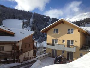 ein Haus im Schnee neben einem Berg in der Unterkunft Dolce Vita in Serfaus
