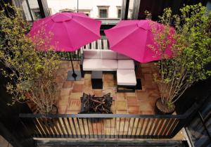 una vista aérea de un patio con 2 sombrillas rosas en Elena de Cobre, Leon, a Member of Design Hotels en León