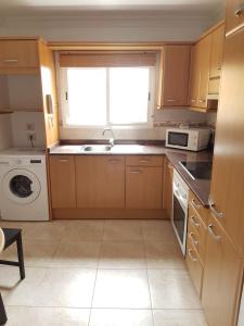 cocina con armarios de madera, fregadero y ventana en The Ruth s house, en Las Palmas de Gran Canaria