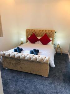 a bedroom with a large bed with red pillows at Dunfermline High Street Flat Ideal For Edinburgh& St. Andrews in Dunfermline