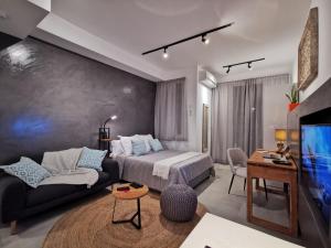 a bedroom with a bed and a couch and a tv at Studio 307 - Ebene Square in Ebene