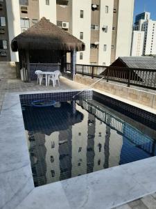 una piscina con mesa y un edificio en Park Way Home Service, en Recife
