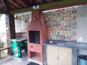 a outdoor kitchen with a brick fireplace and a stove at Otima casa, perto de tudo!! in Porto De Galinhas