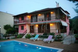 a house with a swimming pool in front of it at Villa Dimitra Nikiana in Nikiana
