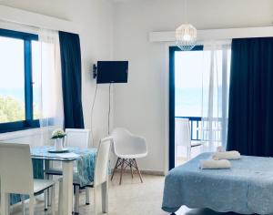 a bedroom with a table and a dining room at Governors Beach Costas Apts in Governor's Beach