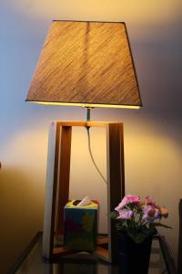 a lamp on a table next to a vase with flowers at The Beachfront Retreat in Rush