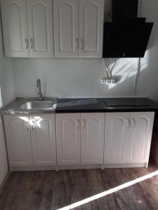 a kitchen with white cabinets and a sink at Новая квартира in Odesa