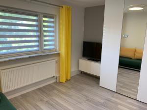 a living room with a television and a window at Comfortable Studio only 20 minutes from International Conference Center Katowice best place for WUF2022 EEC TNF OFF etc in Siemianowice Śląskie