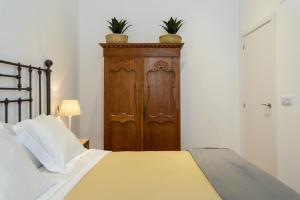 ジローナにあるAPG Palau Salieti 1のベッドルーム1室(ベッド1台付)、木製キャビネットが備わります。