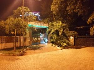 Ayodya Suites Nyali في نيالي: واجهة متجر في الليل مع أشجار النخيل في الأمام