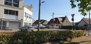 a street with cars parked in front of a building at les lilas in Ozoir-la-Ferrière