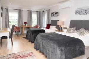 um quarto de hotel com duas camas e uma secretária em The Garrandarragh Inn em Mullinavat