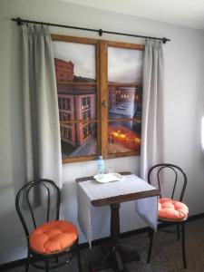 a table and two chairs in front of a window at Pokoje Hotelowe Dux in Łódź