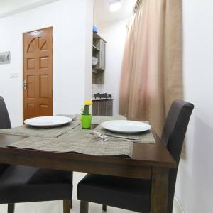 a dining room table with two white plates on it at Resting View One Bedroom Apartment in Male City