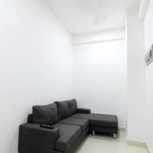 Resting View One Bedroom Apartment في مدينة ماليه: غرفة معيشة مع أريكة رمادية في غرفة بيضاء