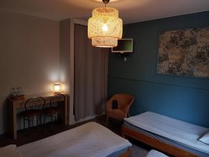 a room with a bed and a table and a lamp at Pokoje Hotelowe Dux in Łódź