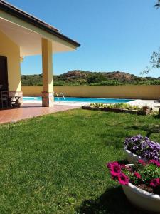 einen Hof mit zwei großen Blumentöpfen im Gras in der Unterkunft B&B Il melograno in Capoterra