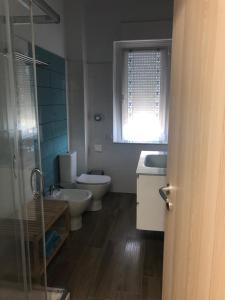 baño con 2 aseos, lavamanos y ventana en Belvedere en Pisa