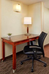 a desk with a chair and a lamp at La Quinta by Wyndham San Diego SeaWorld/Zoo Area in San Diego