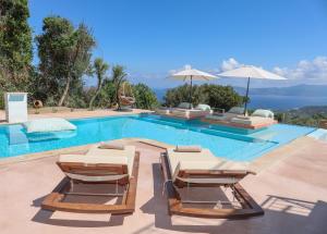 einen Pool mit 2 Liegestühlen und einem Pool in der Unterkunft ANGIO VILLAS SPA in Skiathos-Stadt