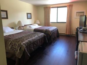 ein Hotelzimmer mit 2 Betten und einem Fenster in der Unterkunft Villagers Inn in Fruitvale