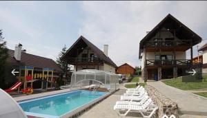een huis met een zwembad en een aantal witte stoelen bij VILLA PARAISO in Skhidnitsa