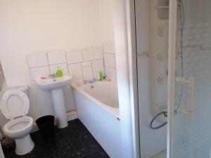 a bathroom with a toilet and a tub and a sink at Cosy Homes in Liverpool