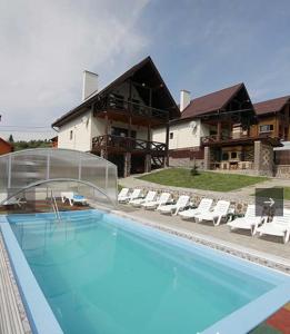 a swimming pool in front of a house at VILLA PARAISO in Skhidnitsa