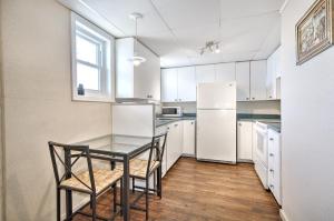 a kitchen with a table and a white refrigerator at Motel Grande Ile in Salaberry de Valleyfield