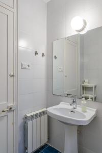 Baño blanco con lavabo y espejo en APG Carrer Nou 10, en Girona