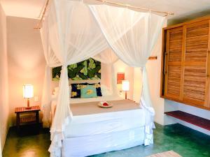 a bedroom with a bed with a canopy at Pousada Beijo do Vento in Arraial d'Ajuda