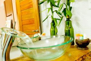 un bol en verre assis sur un comptoir avec des bouteilles dans l'établissement Villa Água de Coco, à Jericoacoara