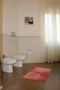 uma casa de banho com um WC, um lavatório e um tapete em Sunny Beach Home em Rometta Marea