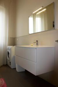 uma casa de banho com um lavatório e uma máquina de lavar roupa em Sunny Beach Home em Rometta Marea