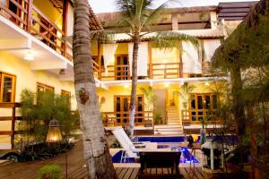 un hotel con piscina y palmeras en Villa Água de Coco, en Jericoacoara