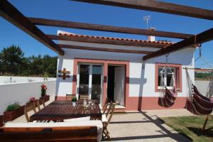 a house with a porch and two american flags at Number 10 Beach House in A dos Cunhados